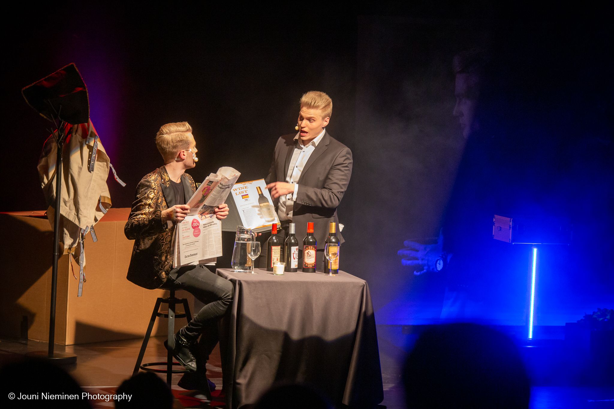 Jari Hynynen ja Aatu Itkonen lavalla esityksessä keskustelemassa pöydän ääressä